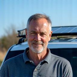 Mick beside solar panels on roof rack